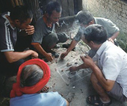 陰雨天,三五瑤民聚在一起玩瑤族傳統(tǒng)“趕豬棋”。