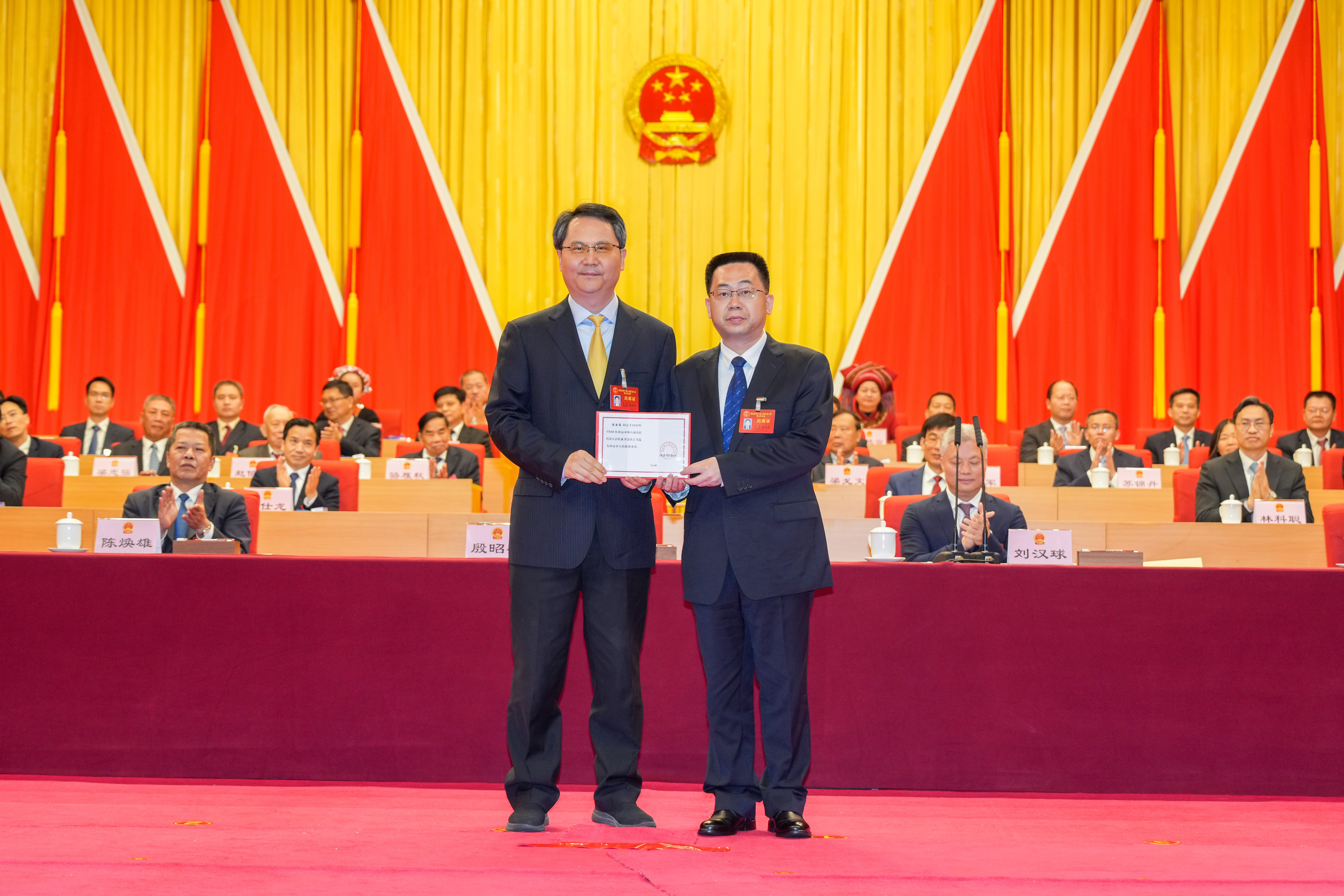 大會主席團常務主席、市委書記、市人大常委會主任殷昭舉為新當選的清遠市人民政府市長陳金鑾頒發(fā)當選證書。